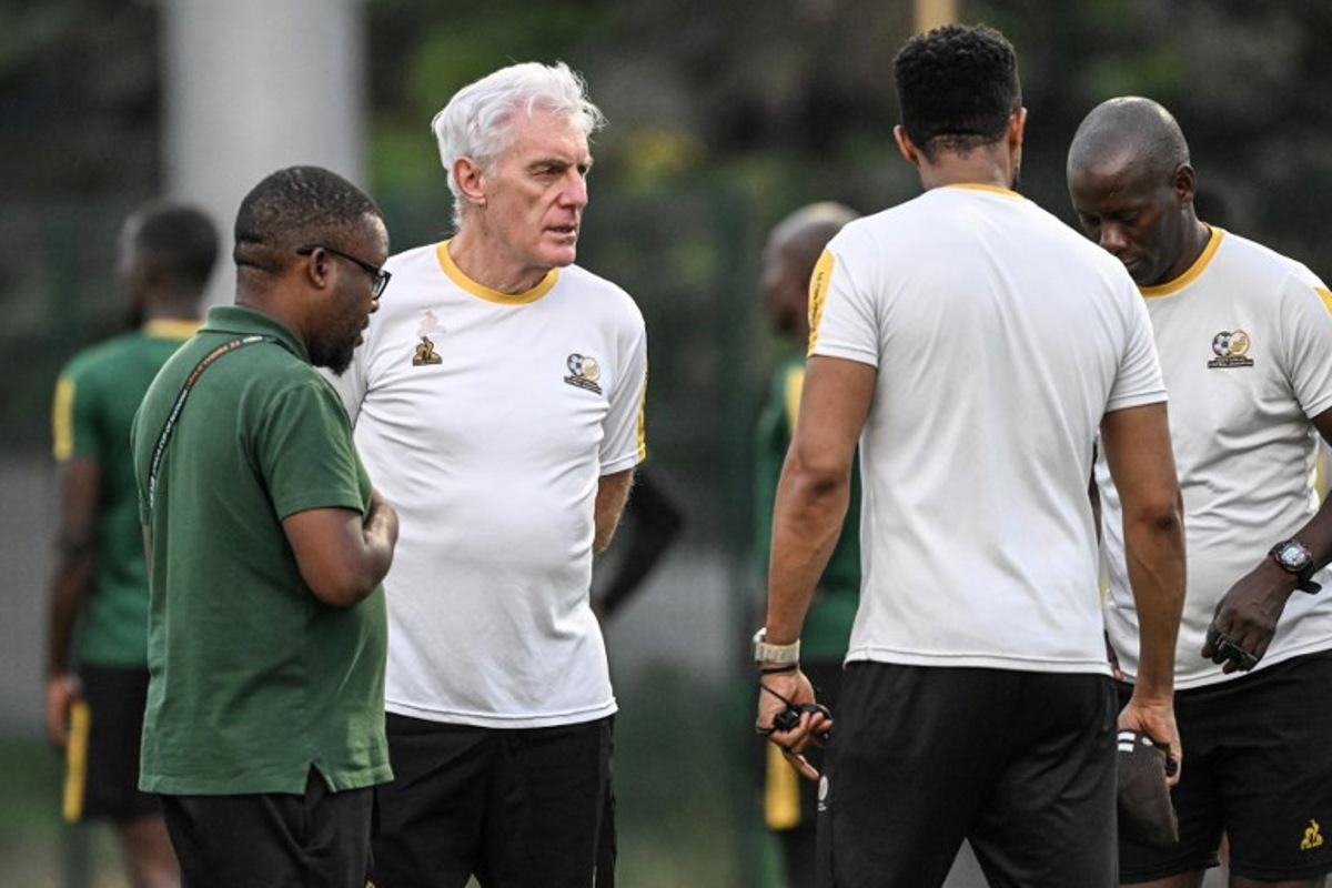 South Africa's headcoach Hugo Broos (C) speaks to South Africa's players as they attend a training session at the Lycee Classique stadium in Abidjan on February 9, 2024, on the eve of the 2024 African Cup of Nations (CAN) football match between South Africa and DR Congo for third place.  Sia KAMBOU / AFP