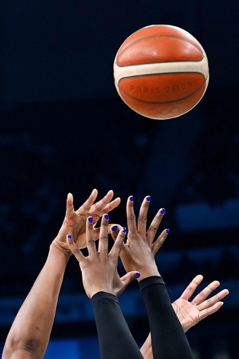 France's #22 Marieme Badiane (L) and Nigeria's #0 Amy Okonkwo go for a rebound in the women's preliminary round group B basketball match between France and Nigeria during the Paris 2024 Olympic Games at the Pierre-Mauroy stadium in Villeneuve-d'Ascq, northern France, on August 1, 2024.  Sameer Al-Doumy / AFP