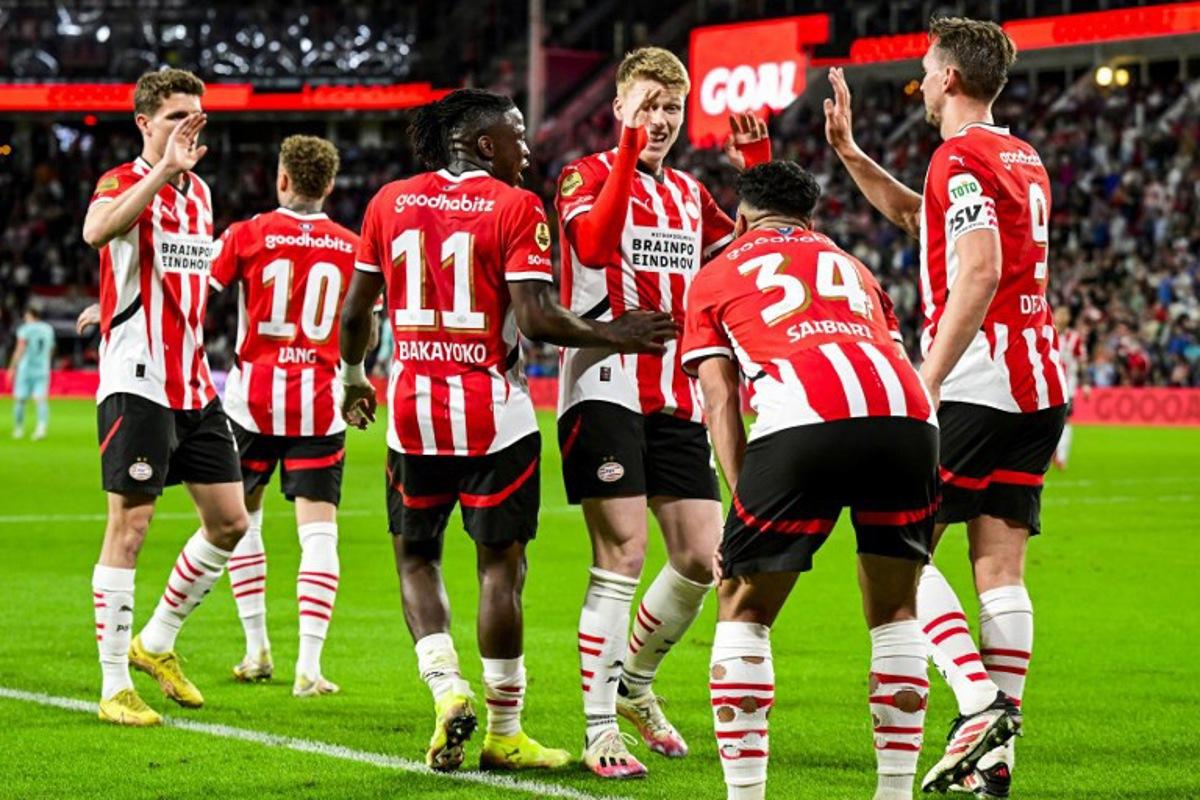PSV's players celebrate after scoring their fifth goal during the Dutch Eredivisie fooball match between PSV Eindhoven and Almere City FC at the Phillips Stadium in Eindhoven on April 12, 2025.  Olaf Kraak / ANP / AFP