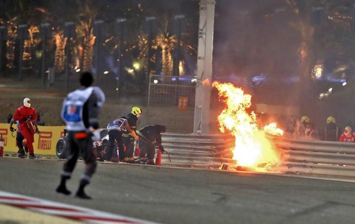 A steward reacts as officials put out a fire on Haas F1's French driver Romain Grosjean car following a crash during the Bahrain Formula One Grand Prix at the Bahrain International Circuit in the city of Sakhir on November 29, 2020.  TOLGA BOZOGLU / POOL / AFP