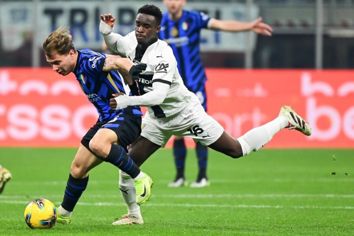 Inter Milan's Italian midfielder #23 Nicolo Barella (L) fights for the ball with Parma's Belgian midlfielder #16 Mandela Keita during the Italian Serie A football match between Inter Milan and Parma at the San Siro stadium in Milan, on December 6, 2024.  Piero CRUCIATTI / AFP