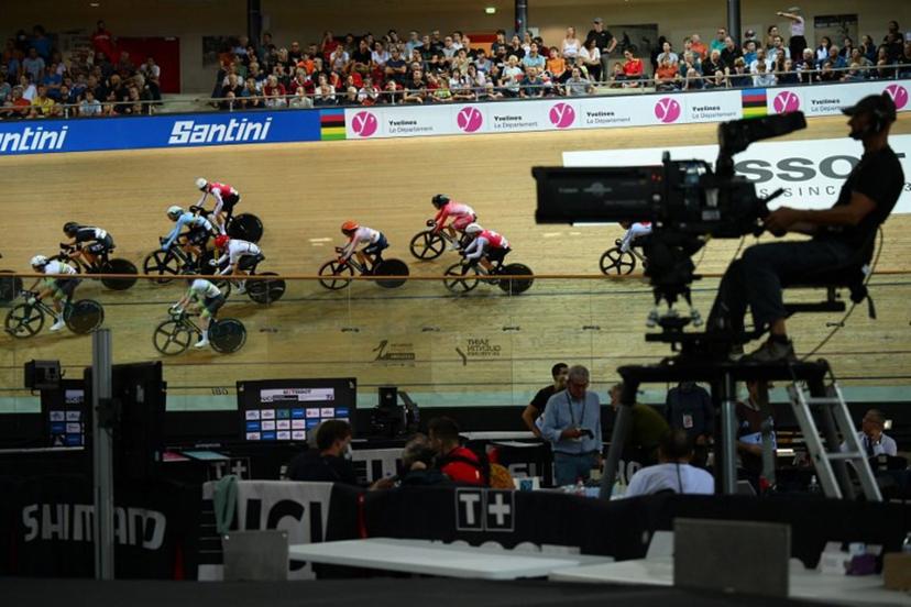 A camera operator films as cyclists compete in the Women's Madison 30km final during the UCI Track Cycling World Championships at the Velodrome of Saint-Quentin-en-Yvelines, southwest of Paris, on October 15, 2022.  Anne-Christine POUJOULAT / AFP