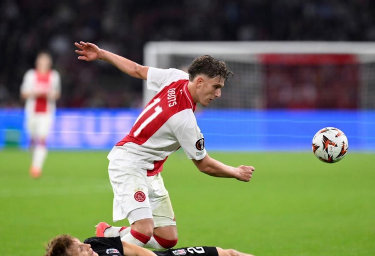Besiktas' Norwegian defender #02 Jonas Svensson (L) tackles Ajax's Belgian forward #11 Mika Godts during the UEFA Europa League football match between Ajax Amsterdam and Besiktas at The Johan Cruijff Arena Stadium in Amsterdam on September 26, 2024.  JOHN THYS / AFP
