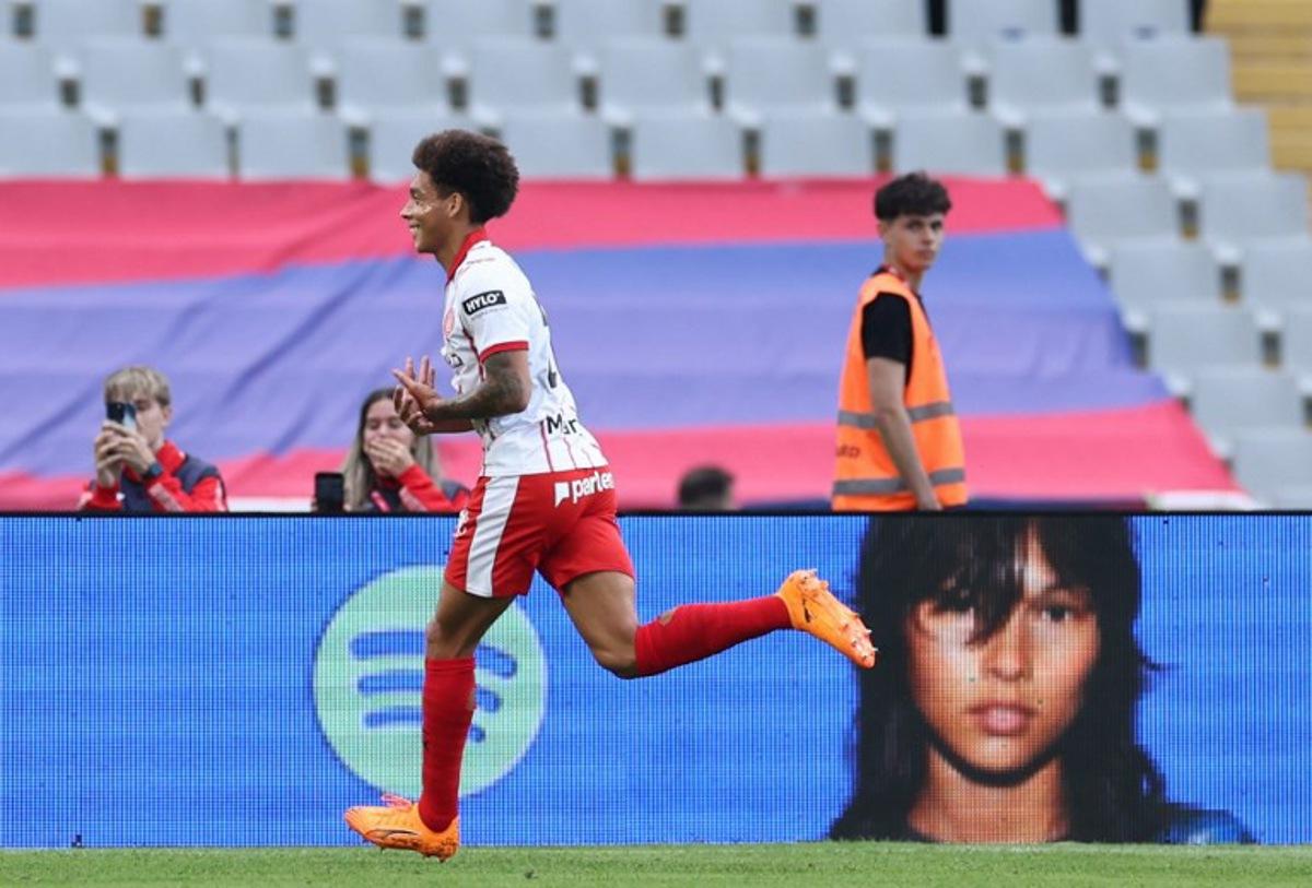 Girona's Belgian defender #20 Axel Witsel celebrates scoring his team's first goal with teammates during the Spanish league football match between FC Barcelona and Girona FC at Estadi Olimpic Lluis Companys in Barcelona on October 18, 2025.  Josep LAGO / AFP