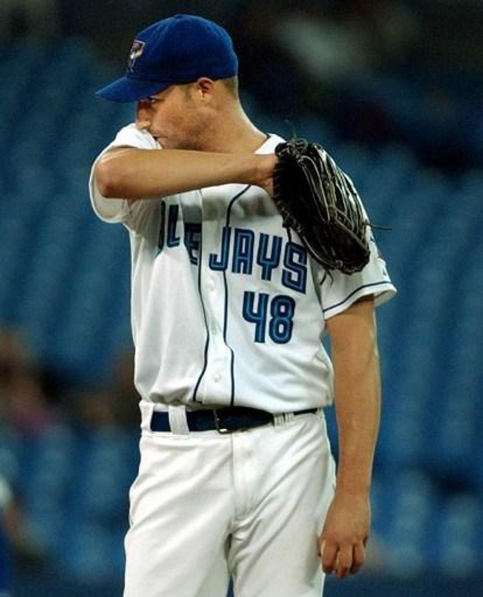 Toronto Blue Jays' starting pitcher Doug Davis wipes his face just before being relieved after giving up five runs tol the Tampa Bay Devil Rays in the second-inning in Toronto on 15 May, 2003. The Rays defeated the Jays 9-5.  AFP PHOTO/J.P. Moczulski
