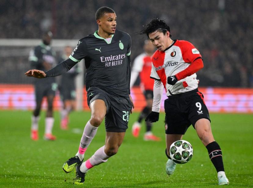 AC Milan's German defender #28 Malick Thiaw (L) fights for the ball with Feyenoord's Japanese forward #09 Ayase Ueda   during the UEFA Champions League knockout phase play-off 1st leg football match between Feyenoord Rotterdam and AC Milan at the Stadion Feijenoord "De Kuip" in Rotterdam, on February 12, 2025.   JOHN THYS / AFP