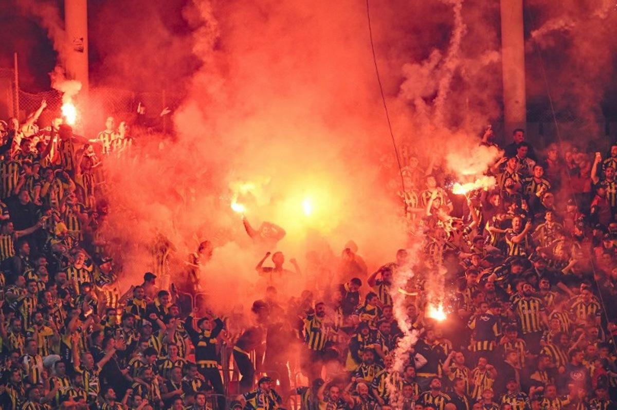 Fenerbahce's fans light smoke flares during the Turkish Super lig football match between Fenerbahce and Galatasaray at the Rams Park stadium in Istanbul, on April 26, 2026.  Yasin AKGUL / AFP