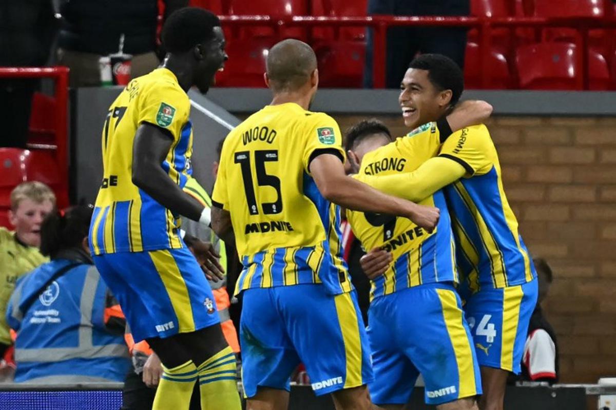 Southampton's Northern Irish midfielder #24 Shea Charles (R) celebrates with teammates after scoring their first goal during the English League Cup third round football match between Liverpool and Southampton at Anfield in Liverpool, north west England on September 23, 2025.  Paul ELLIS / AFP