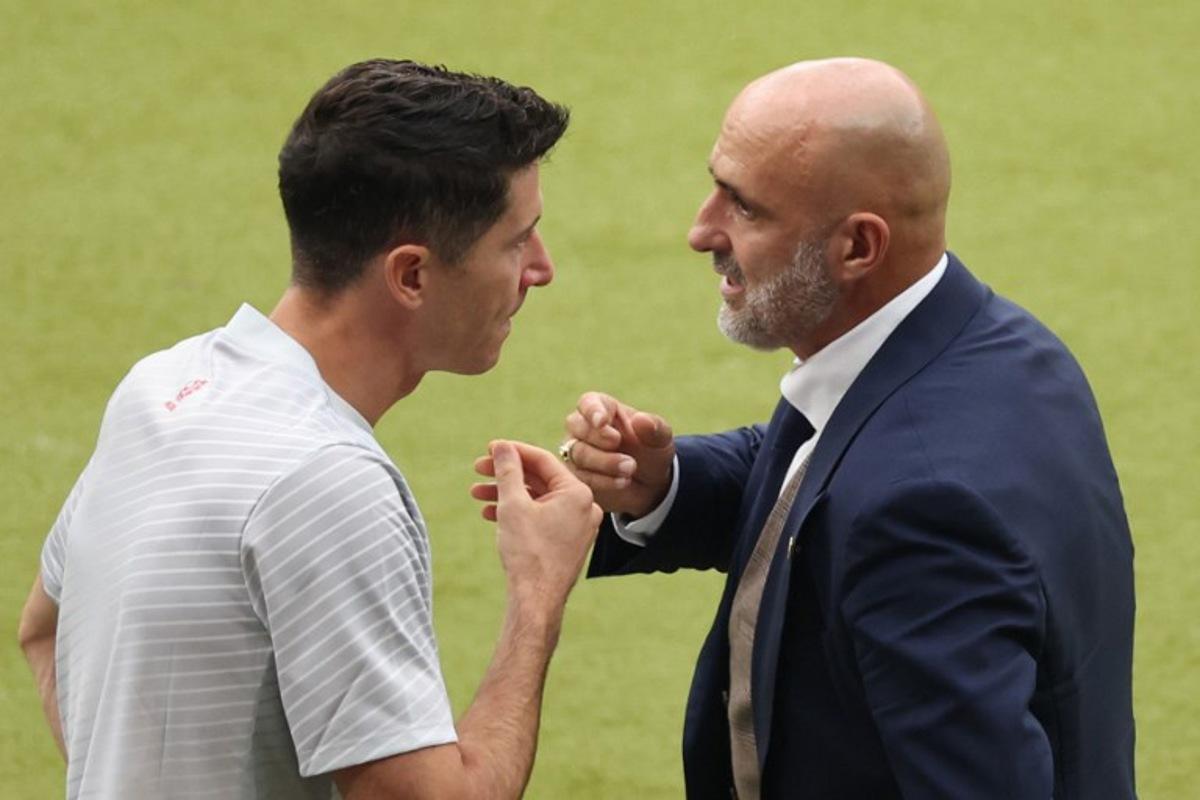 Poland's head coach Michal Probierz speaks with Poland's forward #09 Robert Lewandowski during the UEFA Euro 2024 Group D football match between Poland and Austria at the Olympiastadion in Berlin on June 21, 2024.  Ronny HARTMANN / AFP