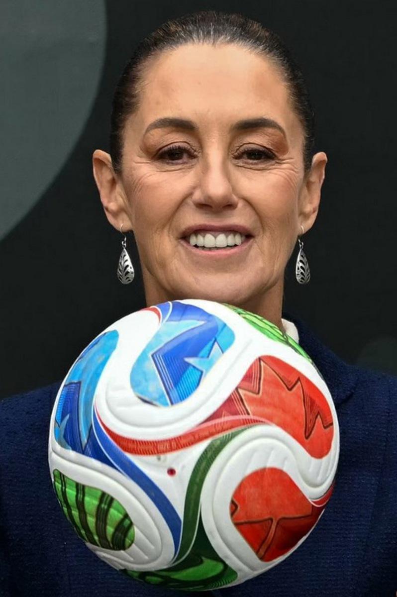 Mexican President Claudia Sheinbaum holds a FIFA Wold Cup 2026 official ball during a a presentation of the organization plan for the tournament in Mexico City, on November 10, 2025.  CARL DE SOUZA / AFP
