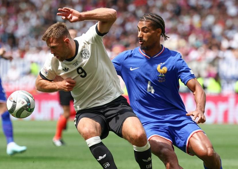 Germany's forward #09 Niclas Fullkrug (L) and France's defender #04 Loic Bade vie for the ball during the UEFA Nations League third place play-off football match between Germany and France in Stuttgart, southwestern Germany on June 8, 2025.  FRANCK FIFE / AFP