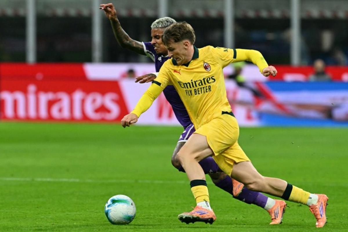 AC Milan's Begian midfielder #56 Alexis Saelemaekers fights for the ball with Fiorentina's Brazilian defender #02 Dodo during the Italian Serie A football match between AC Milan and Fiorentina at San Siro stadium in Milan, northern Italy, on October 19, 2025.  Stefano RELLANDINI / AFP