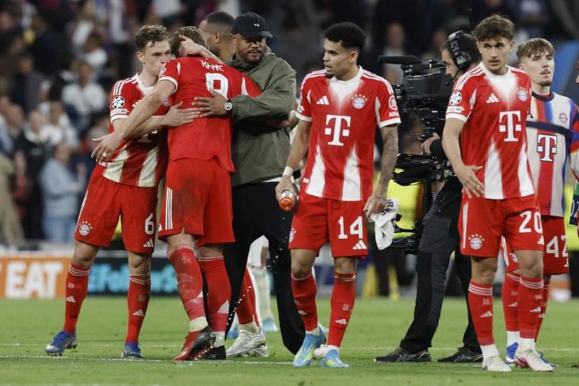 Bayern Munich's Belgian head coach Vincent Kompany (3L) celebrates with players at the end the UEFA Champions League quarter final first leg football match between Real Madrid CF and FC Bayern Munich at Santiago Bernabeu Stadium in Madrid on April 7, 2026.  Oscar DEL POZO / AFP