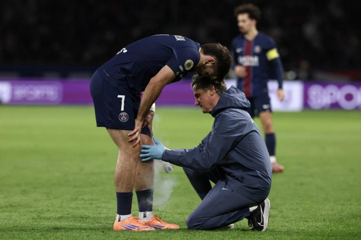 (FILES) Paris Saint-Germain's Georgian forward #07 Khvicha Kvaratskhelia receives medical assistance after suffering an injury during the French L1 football match between Paris Saint-Germain (PSG) and Auxerre at the Parc des Princes stadium in Paris on September 27, 2025. Kvaratskhelia, absent for the trip to Barcelona ahead of the UEFA Champions League first round day 2 football match.  FRANCK FIFE / AFP