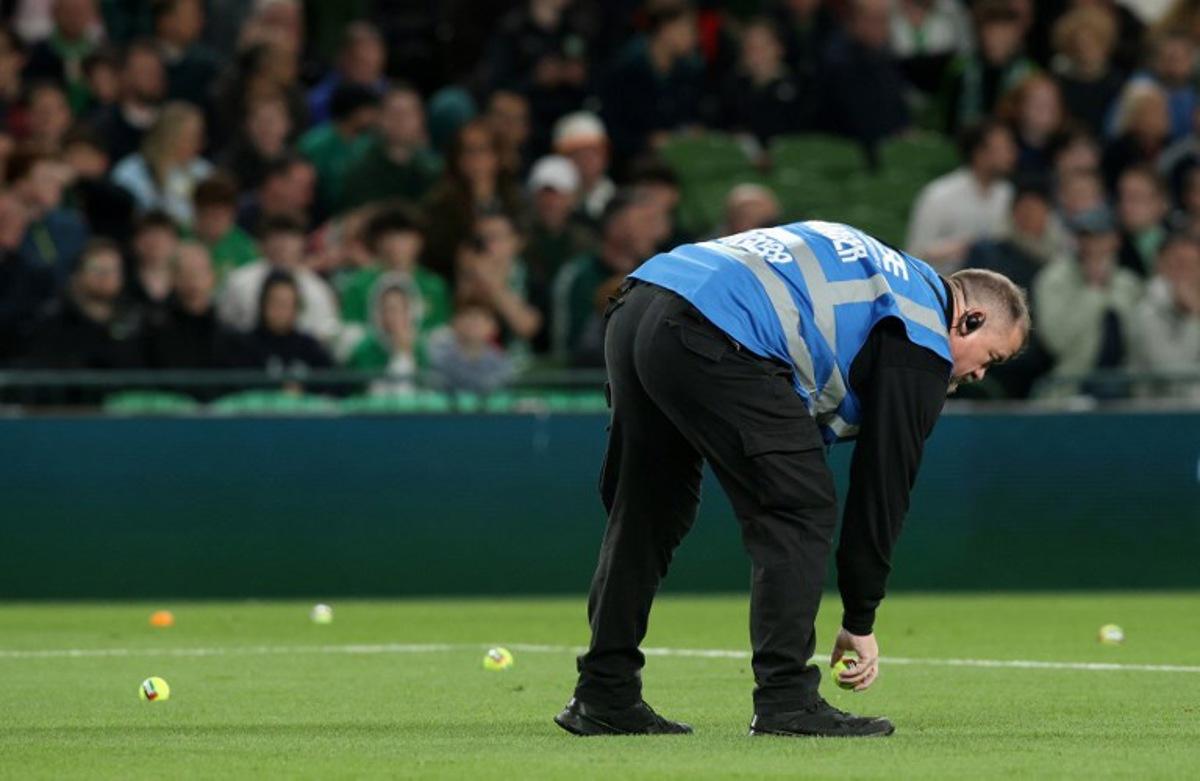 An official collects tennis thrown onto the pitch during the UEFA Nations League, League B - Group 3, football match between Republic of Ireland and Austria at the Aviva Stadium in Dublin, Ireland on October 1, 2026.  Paul Faith / AFP