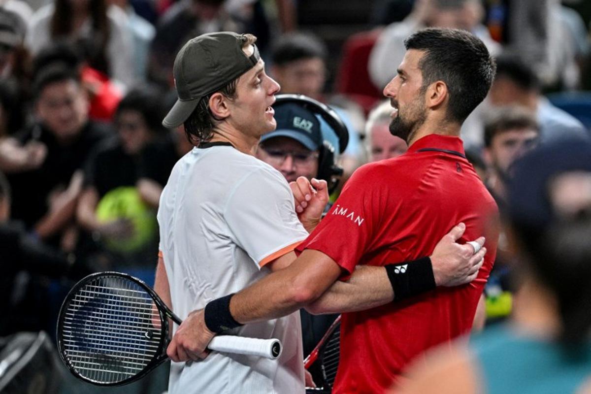 Serbia's Novak Djokovic (R) shakes hands with Belgium's Zizou Bergs at the end of their quarter-final men's singles match at the Shanghai Masters tennis tournament in Shanghai on October 9, 2025.  Hector RETAMAL / AFP