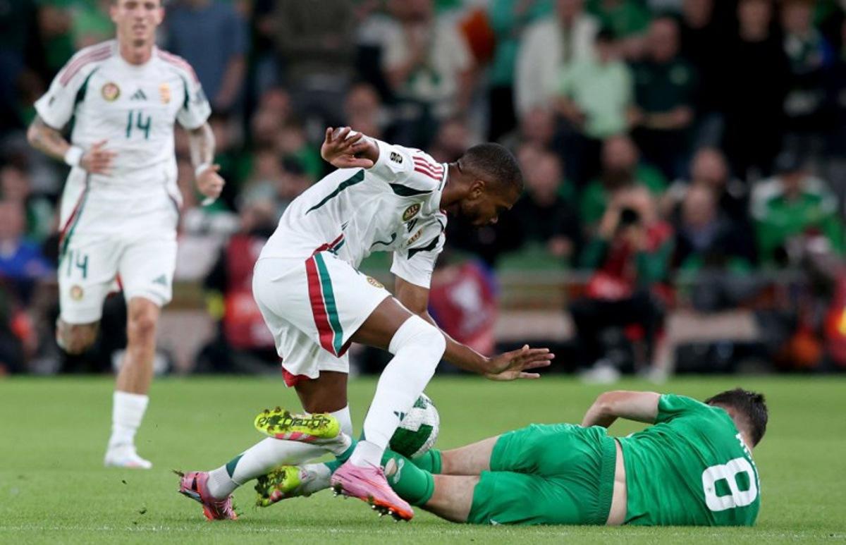 Hungary's goalkeeper #12 Balazs Toth battles for the ball with Republic of Ireland's midfielder #08 Jason Knight during the 2026 World Cup Group F qualifier football match between Republic of Ireland and Hungary, at Aviva Stadium, in Dublin, on September 6, 2025.   Paul Faith / AFP