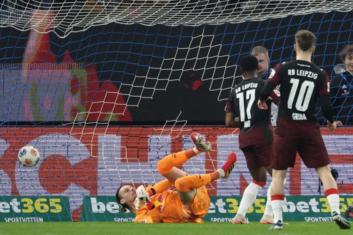 Leipzig's Belgian goalkeeper #26 Maarten Vandevoordt (L) fails to save the opening goal during the German first division Bundesliga football match between Hamburger SV and RB Leipzig in Hamburg, northern Germany on March 1, 2026.  IBRAHIM OT / AFP