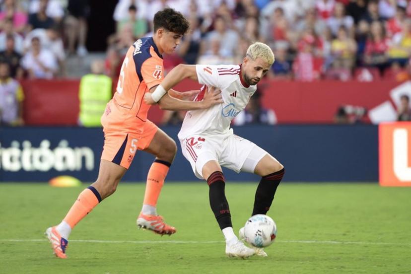 Barcelona's Spanish defender #05 Pau Cubarsi (L) and Sevilla's Belgian forward #24 Adnan Januzaj fight for the ball during the Spanish league football match between Sevilla FC and FC Barcelona at Ramon Sanchez Pizjuan Stadium in Seville on October 5, 2025.  CRISTINA QUICLER / AFP