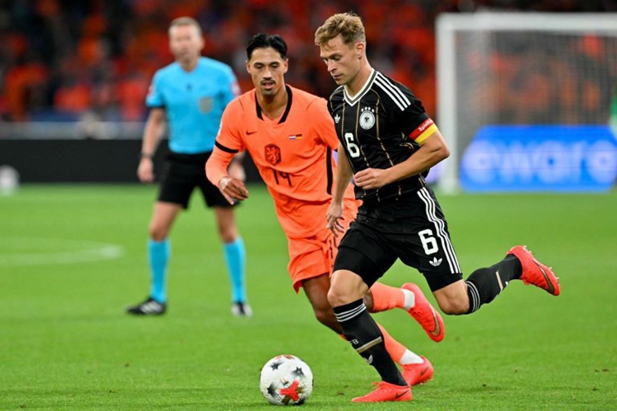 Netherlands' midfielder #14 Tijjani Reijnders (L) fights for the ball with Germany's midfielder #06 Joshua Kimmich during the UEFA Nations League (League A, Group A2) football match between Netherlands and Germany at Johan Cruijff ArenA in Amsterdam on September 24, 2026.  NICOLAS TUCAT / AFP