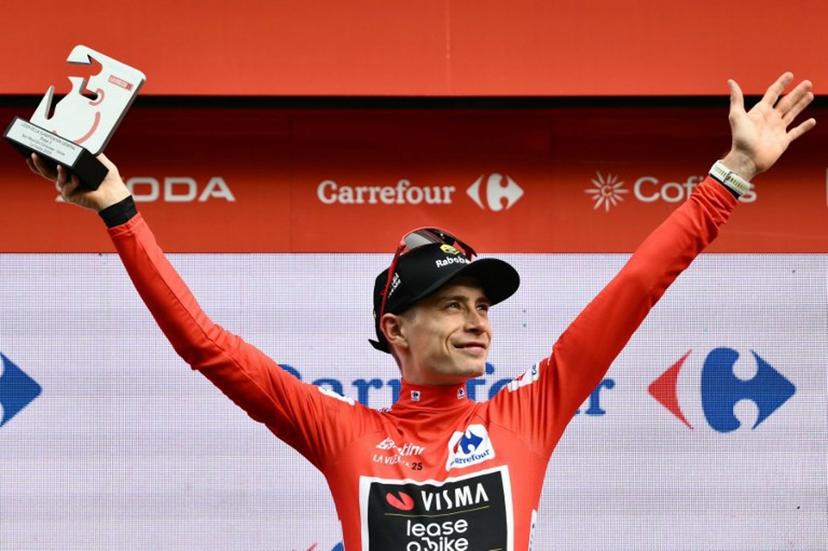 Team Visma-Lease a bike's Danish rider Jonas Vingegaard celebrates on the podium wearing the overall leader's red jersey after the third stage of the Vuelta a Espana, a 134 km race between San Maurizio Canavese and Ceres, in Italy's Piemonte region, on August 25, 2025.    Marco BERTORELLO / AFP