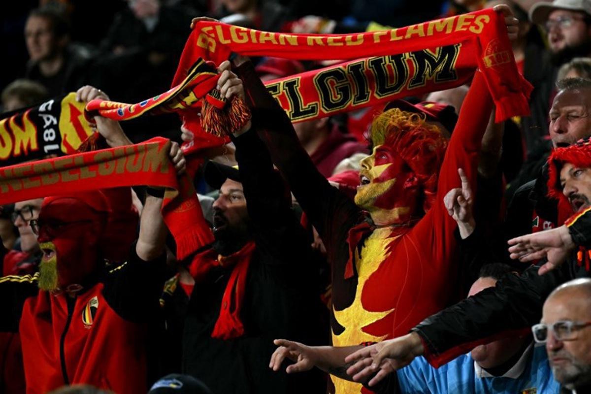 Fans holds aloft scarves during the 2026 World Cup Group J qualifier football match between Wales and Belgium, at Cardiff City Stadium, in Cardiff, on October 13, 2025.   Paul ELLIS / AFP