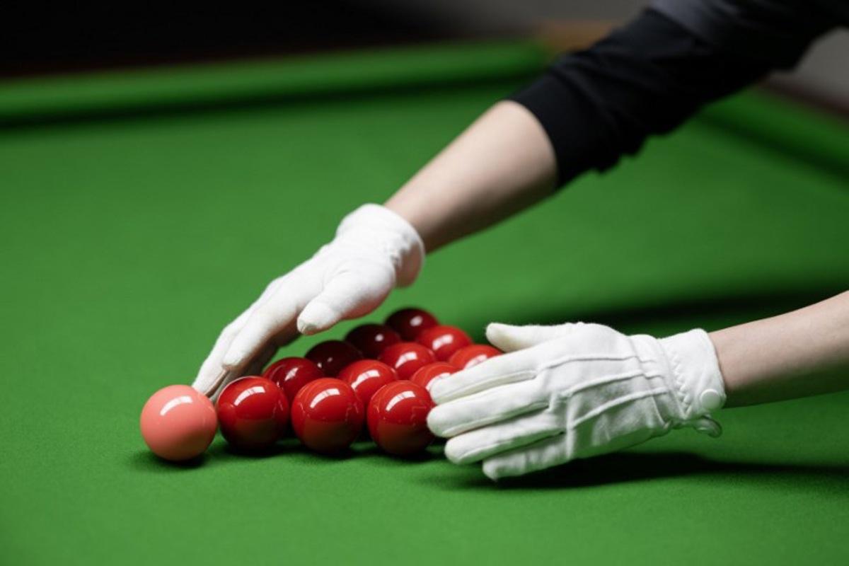 Cody Liu racks snooker balls for his son, the Hong Kong born snooker player Shaun Liu, aged 15, as he practices in the Ding Junhui Snooker Academy in the centre of Sheffield, northern England on September 10, 2025.  Since 1977 the Snooker World Championship has been held every year in Sheffield's 980-seat Crucible Theatre, with an estimated 500 million spectators watching the televised broadcast across 150 countries. China's Zhao Xintong is the reigning World Snooker Champion, the  first Asian player to win the title, whilst China's Bai Yulu is the reigning winner of the World Women's Snooker Championship. Snooker remains incredibly popular in China, with around 50 million people playing the game and approximately 300,000 snooker clubs, however many professional Chinese players are based in Sheffield, England as the widely-acknowledged home of the sport. Oli SCARFF / AFP
