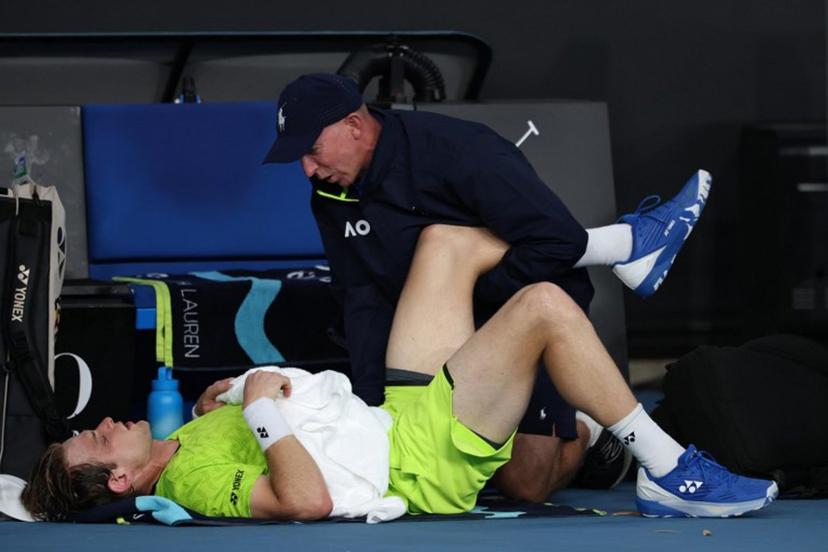 A physio attends to Belgium's Zizou Bergs between points against Poland's Hubert Hurkacz during their men's singles match on day three of the Australian Open tennis tournament in Melbourne on January 20, 2026.  IZHAR KHAN / AFP