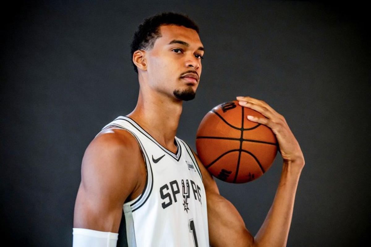 French basketball player Victor Wembanyama poses for promotional photos during the San Antonio Spurs media day at the Victory Capital Performance Center in San Antonio, Texas on September 29, 2025. After making a thunderous return to the court on Wednesday with a 40-point performance, French phenomenon Victor Wembanyama has not escaped the eternal debate about height in the NBA -- where measurements are often surrounded by a certain amount of mystery. A clerical error before the start of the season reignited the rumor mill around the San Antonio Spurs star, who says he is "surprised that it's still a conversation". SERGIO FLORES / AFP