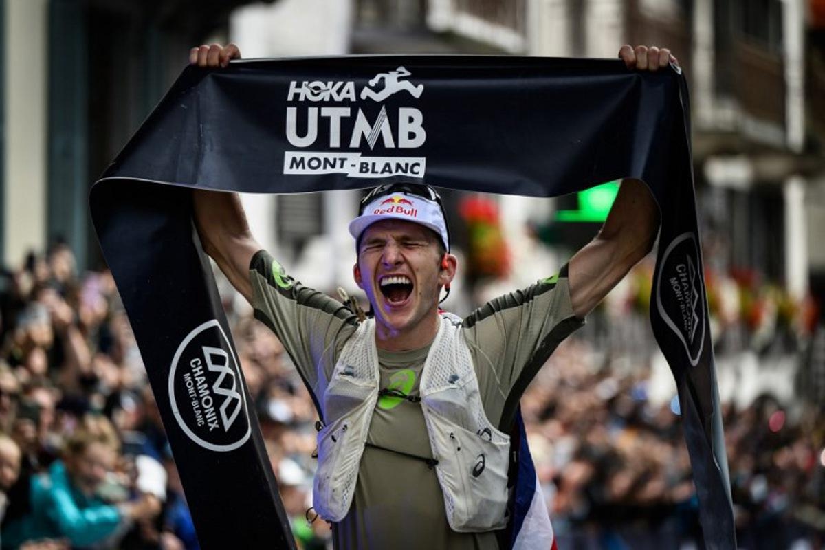 British Tom Evans celebrates as he crosses the finish line at the end of the 22nd edition of the Ultra Trail du Mont Blanc (UTMB), a 174km trail race crossing France, Italy and Switzerland, in Chamonix, south-eastern France on August 30, 2025.  The Briton Tom Evans, 33 years old, won on August 30, 2025 the 22nd edition of the Ultra-Trail of Mont-Blanc in Chamonix (Haute-Savoie), following a grueling race marked by severe weather conditions and numerous dropouts. JEFF PACHOUD / AFP