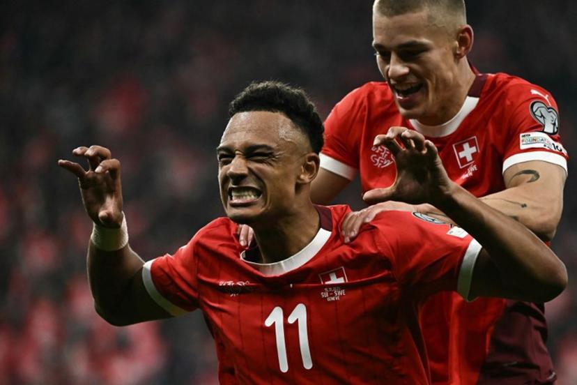 Switzerland's forward #11 Dan Ndoye (L) celebrates after scoring his team's third goal during the FIFA World Cup 2026 Group B European qualification football match between Switzerland and Sweden at the Geneva stadium, in Geneva, on November 15, 2025.  Fabrice COFFRINI / AFP