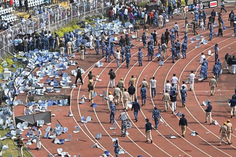 Security personnel try to control the crowd as Inter Miami's Argentine forward #10 Lionel Messi departs from the Salt Lake Stadium in Kolkata on December 13, 2025. Thousands of fans packed into a stadium in eastern India on December 13 to cheer on Lionel Messi as the football legend unveiled a 21-metre (70-foot) statue of himself.  Dibyangshu SARKAR / AFP