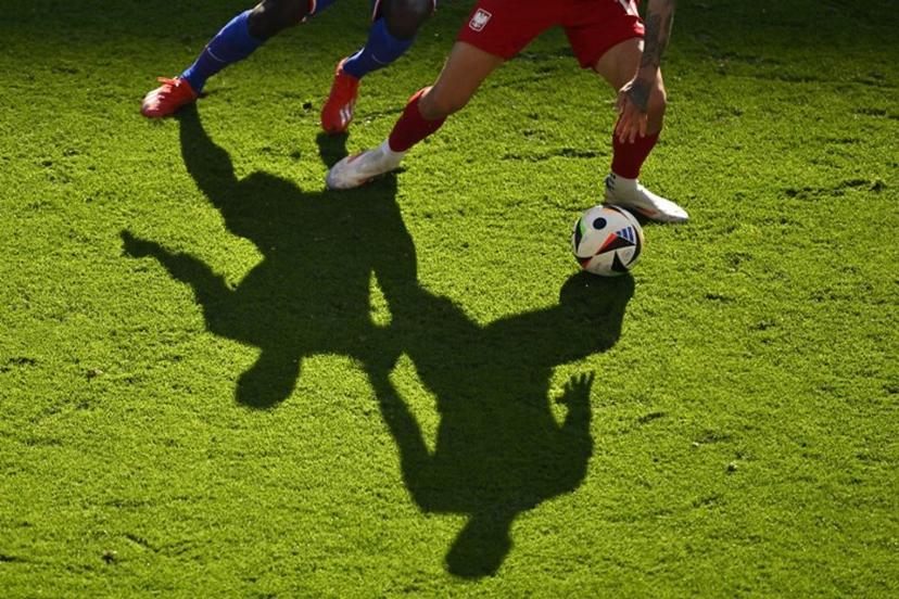 Shadows of players are cast on the pitch as they vie for the ball during the UEFA Euro 2024 Group D football match between France and Poland at the BVB Stadion in Dortmund on June 25, 2024.  INA FASSBENDER / AFP