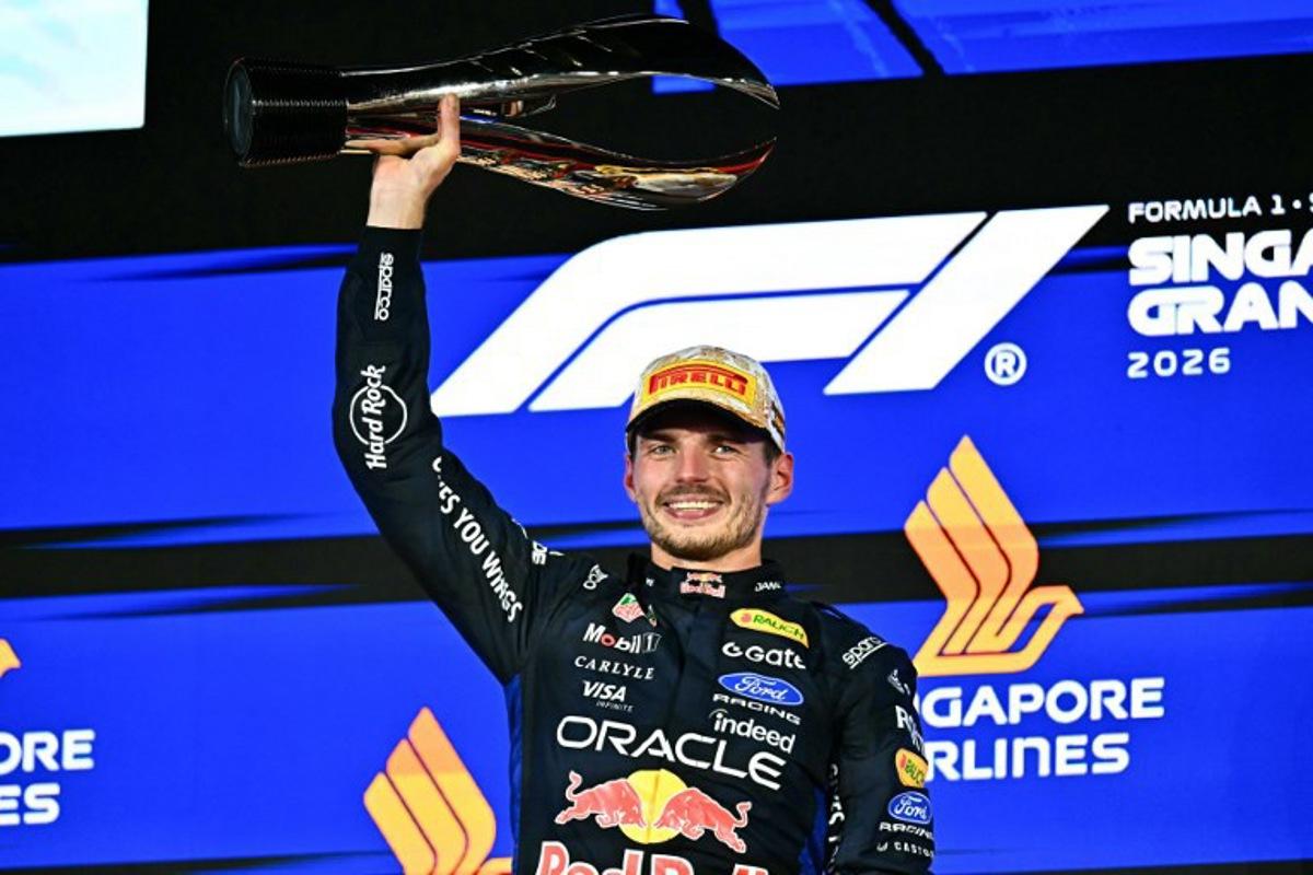 Winner Red Bull Racing's Dutch driver Max Verstappen lifts his trophy as he celebrates on the podium after the Formula One Singapore Grand Prix at the Marina Bay Street Circuit in Singapore on October 11, 2026.  Lillian SUWANRUMPHA / AFP