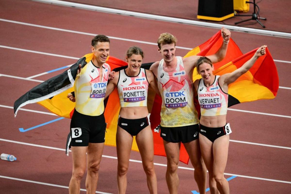Belgium's Dylan Borlee (L), Belgium's Helena Ponette, Belgium's Alexander Doom and Belgium's Imke Vervaet celebrate with their country's flag at the end of the mixed 4x400m relay final during the World Athletics Championships in Tokyo on September 13, 2025.  Yuichi YAMAZAKI / AFP