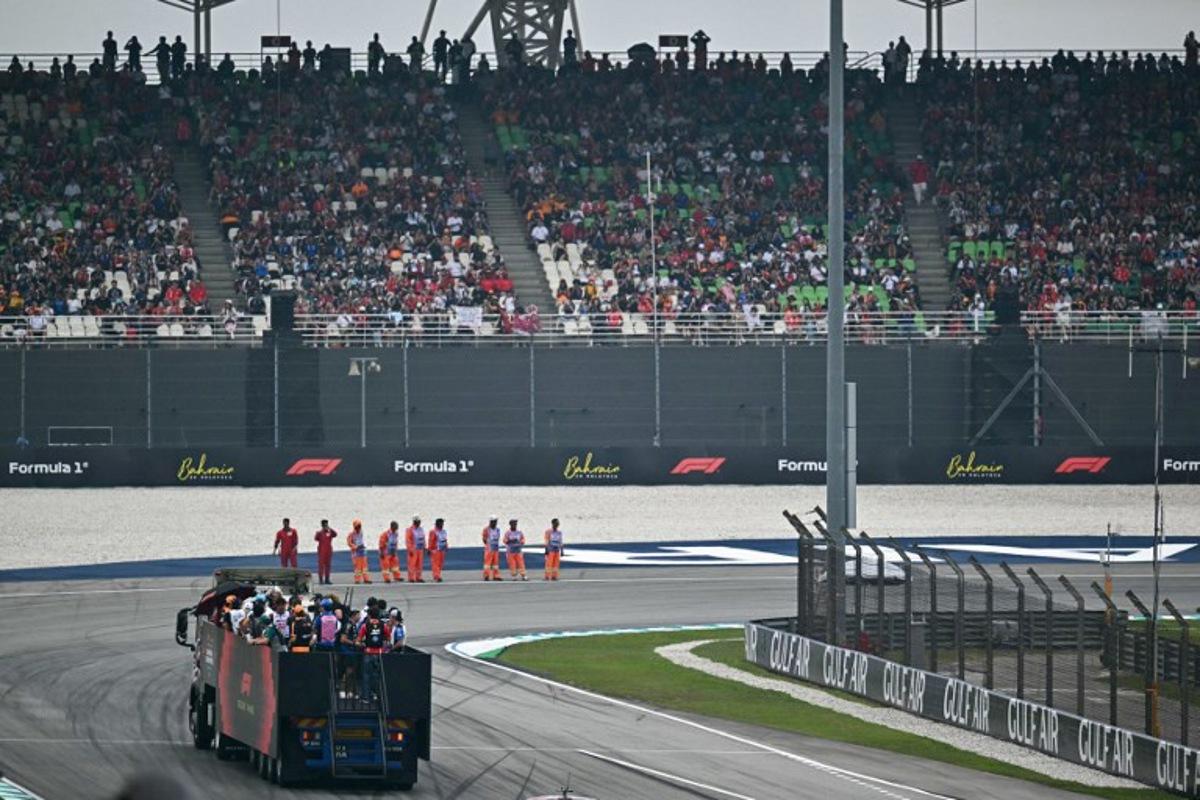 Supporters watch as drivers ride on a truck during the Driver's Parade ahead of the Formula One Bahrain Grand Prix in Sepang on October 4, 2026.  Lillian SUWANRUMPHA / AFP