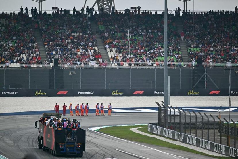Supporters watch as drivers ride on a truck during the Driver's Parade ahead of the Formula One Bahrain Grand Prix in Sepang on October 4, 2026.  Lillian SUWANRUMPHA / AFP