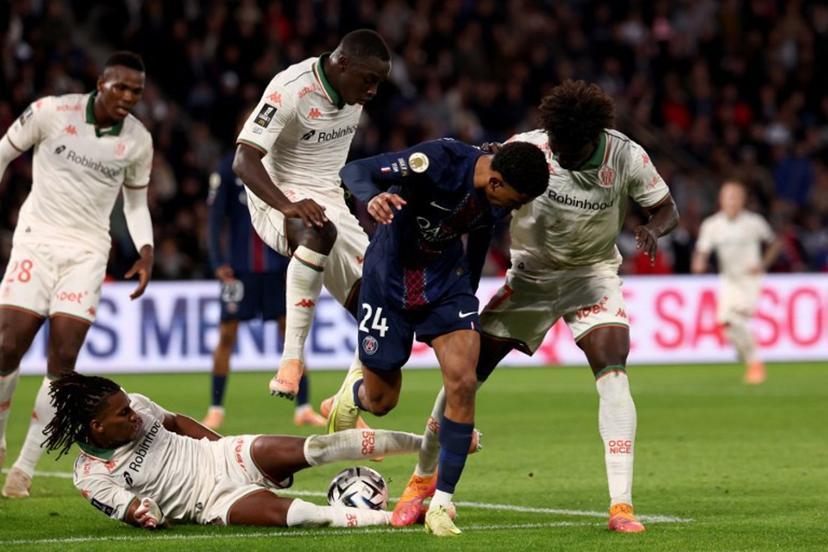 Nice's Algerian midfielder #06 Hicham Boudaoui (bottom) tackles Paris Saint-Germain's French midfielder #24 Senny Mayulu (C) during the French L1 football match between Paris Saint-Germain (PSG) and OGC Nice at the Parc des Princes stadium in Paris on November 1, 2025.  FRANCK FIFE / AFP