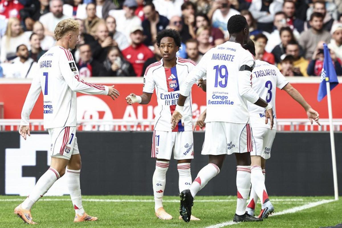 Lyon's players celebrate their team's first goal during the French L1 football match between Lille LOSC and Olympique Lyonnais (OL) at the Stade Pierre-Mauroy in Villeneuve-d'Ascq, northern France, on September 28, 2025.  Sameer Al-DOUMY / AFP