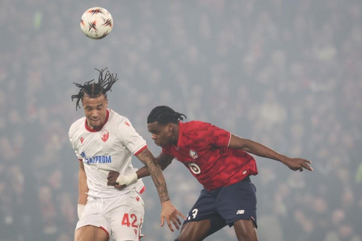 Crvena Zvezda Beograd's Dutch forward #42 Jay Enem (L) fights for the ball with Lille's Belgian defender #03 Nathan Ngoy (C) during the UEFA Europa League - knockout round play-off first leg - football match between LOSC Lille and FK Crvena Zvezda Beograd (Red Star Belgrade) at the Pierre Mauroy Stadium in Villeneuve d'Ascq, northern France, on February 19, 2026.  Francois LO PRESTI / AFP