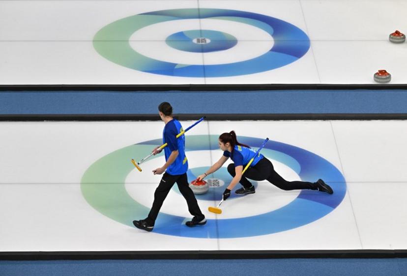 Ukraine's Marharyta Lytvynenko (R) and Artem Shlyk (L) compete against Qatar in the curling mixed doubles round robin session 14 during the Gangwon 2024 Winter Youth Olympic Games at Gangneung Curling Centre in Gangneung on January 31, 2024.  Jung Yeon-je / AFP