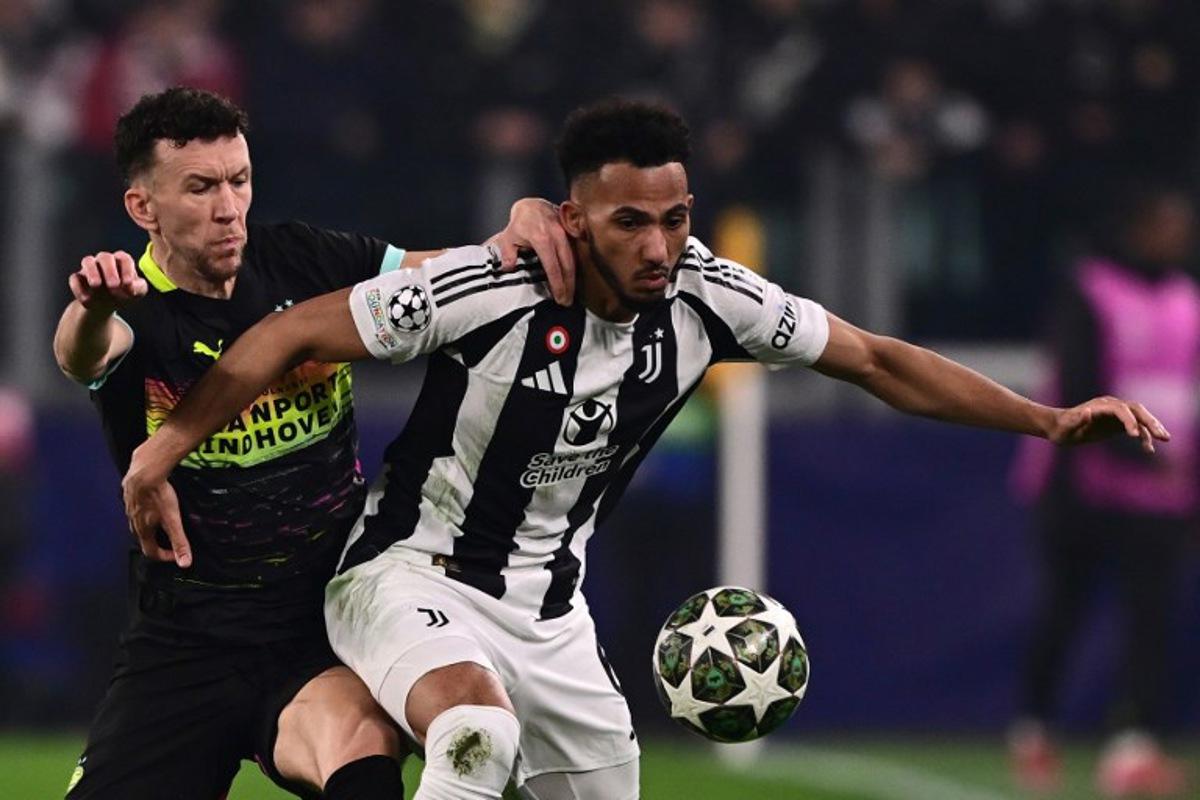 Juventus' British defender #06 Lloyd Kelly (R) fights for the ball with PSV Eindhoven's Croatian forward #05 Ivan Perisic during the UEFA Champions League knockout phase play-off 1st leg football match between Juventus and PSV Eindhoven at the Allianz stadium in Turin, on February 11, 2025.  Marco BERTORELLO / AFP