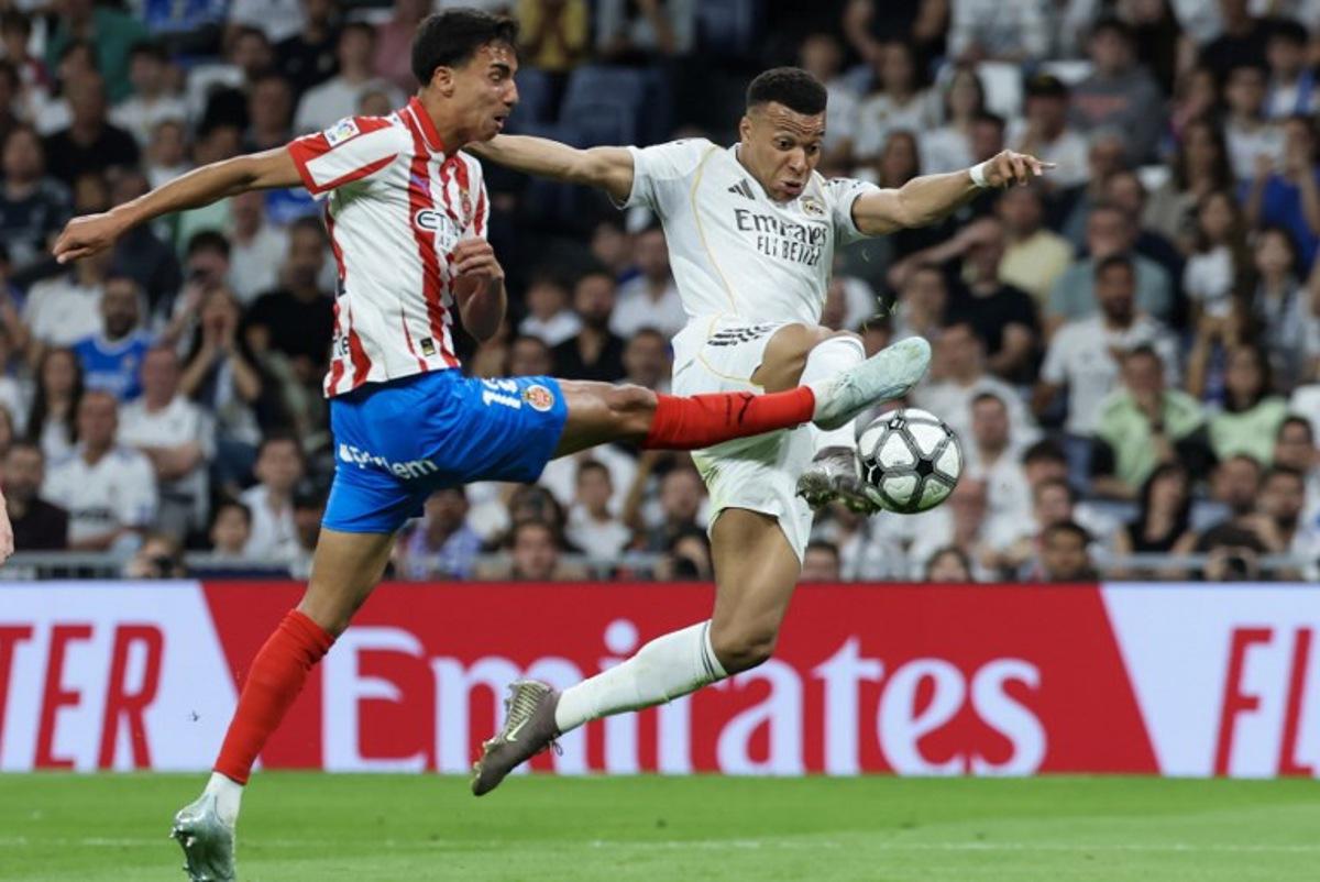Real Madrid's French forward #10 Kylian Mbappe (R) is challenged by Girona's Brazilian defender #12 Vitor Reis during the Spanish league football match between Real Madrid CF and Girona FC at the Santiago Bernabeu stadium in Madrid on April 10, 2026.  Thomas COEX / AFP