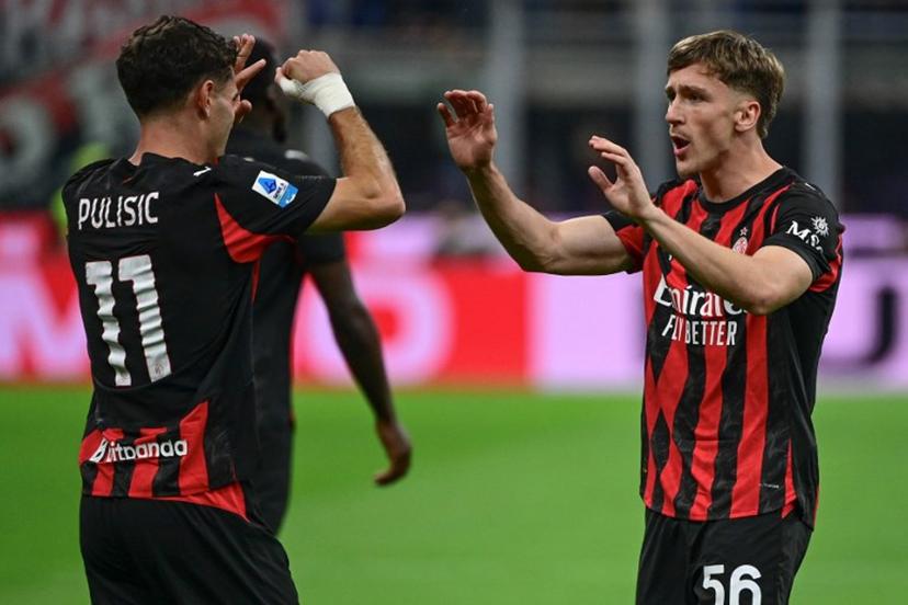 AC Milan's Begian midfielder #56 Alexis Saelemaekers (R) celebrates with his teammate AC Milan's US forward #11 Christian Pulisic after scoring his team's opening goal during the Italian Serie A football match between AC Milan and SSC Napoli at San Siro stadium in Milan, northern Italy, on September 28, 2025.  Piero CRUCIATTI / AFP