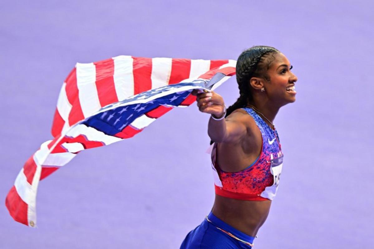 Gold medallist US' Masai Russell celebrates after the women's 100m hurdles final of the athletics event at the Paris 2024 Olympic Games at Stade de France in Saint-Denis, north of Paris, on August 10, 2024.  Martin  BERNETTI / AFP