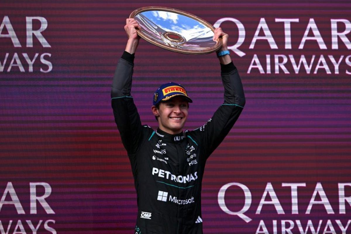 Mercedes' British driver George Russell celebrates on the podium after winning the Formula One Australian Grand Prix at the Albert Park Circuit in Melbourne on March 8, 2026.   WILLIAM WEST / AFP
