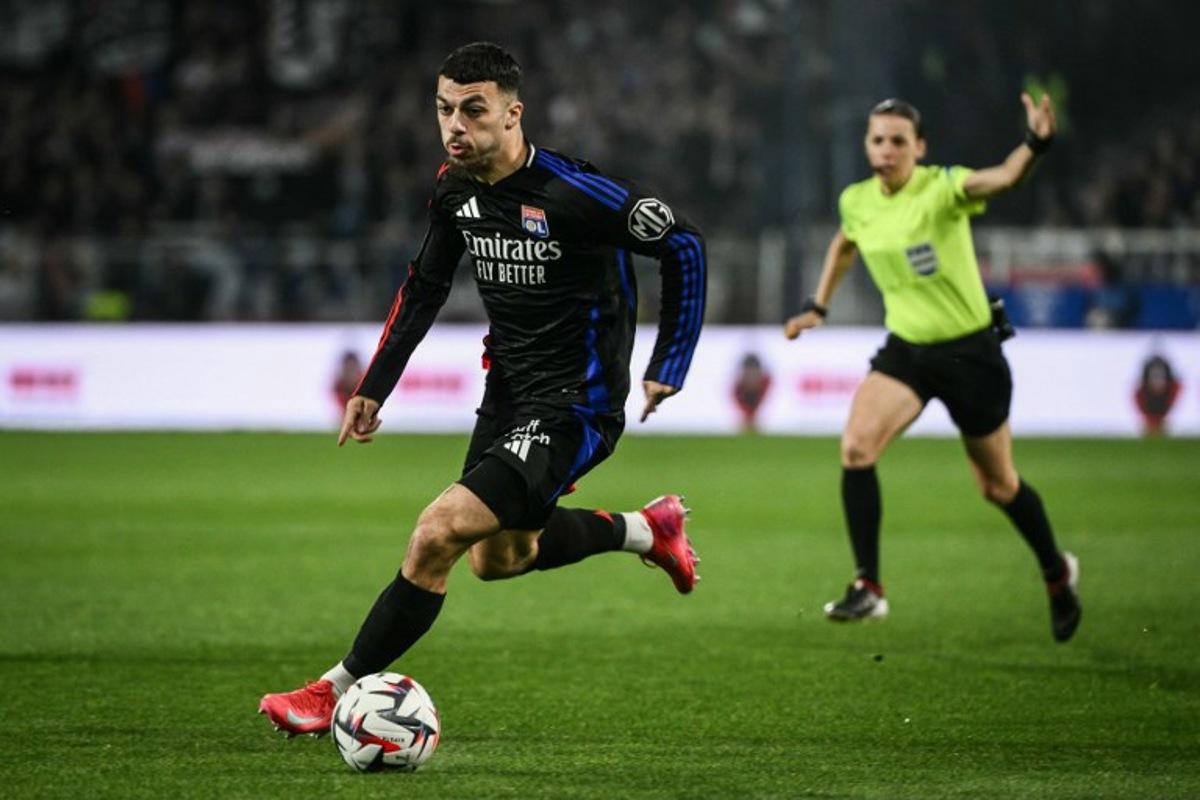 Lyon's Georgian forward #69 Georges Mikautadze runs with the ball during the French L1 football match between AJ Auxerre and Olympique Lyonnais (OL) at Stade de l'Abbe-Deschamps in Auxerre, central France, on April 13, 2025.  ARNAUD FINISTRE / AFP