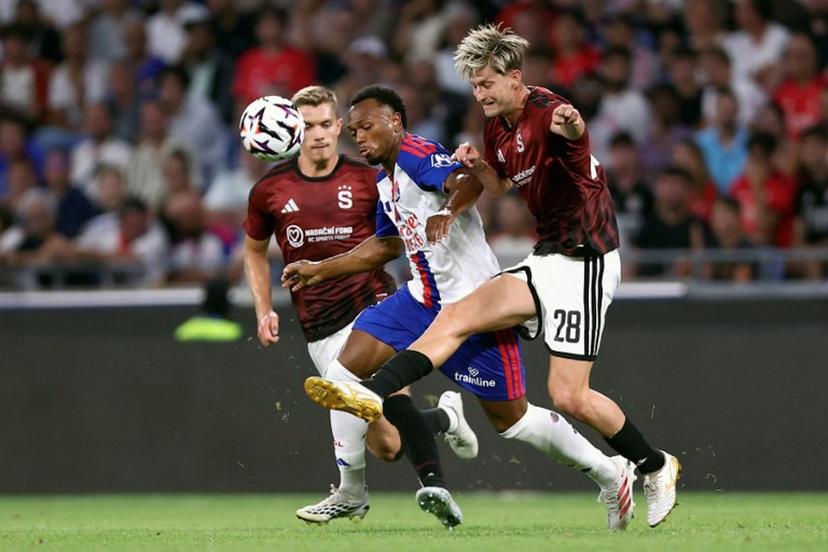 Lyon's Belgian forward #17 LoÏs Openda (C) fights for the ball with Sparta Praha's Czech midfielder #28 Roman Macek (R) during the UEFA Champions League third qualifying round - second leg football match between Olympique Lyonnais (OL) and Sparta Prague at Groupama Stadium in Decines-Charpieu, central-eastern France on August 11, 2026.  Alex MARTIN / AFP