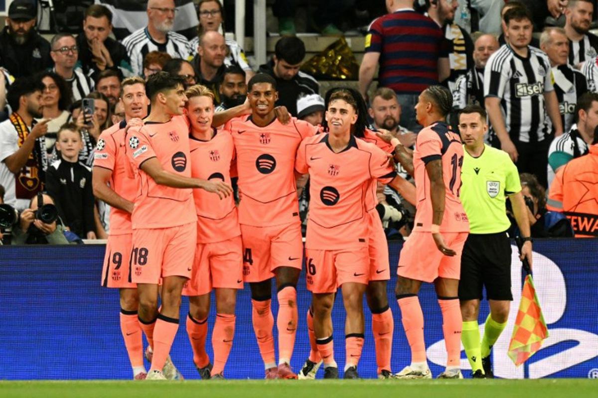 Barcelona's British forward #14 Marcus Rashford (C) celebrates with teammates after scoring his team's second goal during the UEFA Champions League first round football match between Newcastle United FC and FC Barcelona at St James' Park in Newcastle, on September 18, 2025.  Oli SCARFF / AFP