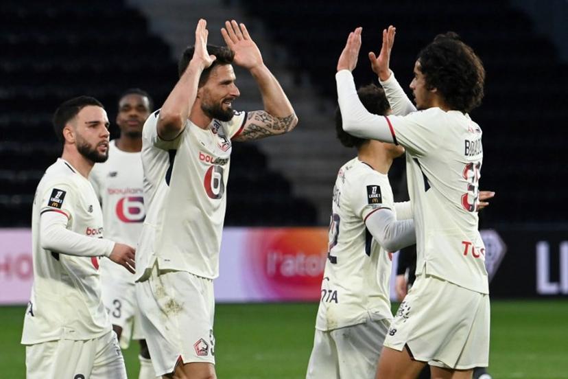 Lille's French forward #09 Olivier Giroud (C) celebrates with teammates after scoring his team's first goal from the penalty spot during the French L1 football match between SCO Angers and Lille LOSC at the Raymond-Kopa Stadium in Angers, western France, on February 22, 2026.  JEAN-FRANCOIS MONIER / AFP